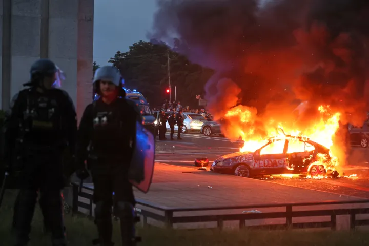 A car burns as PSG supporters celebrate in Paris