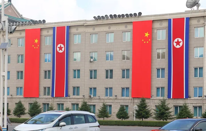 AP A building is decorated with the flags of China and North Korea in Pyongyang