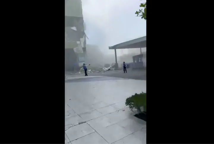 AP This image from a video shows dust and debris outside a building