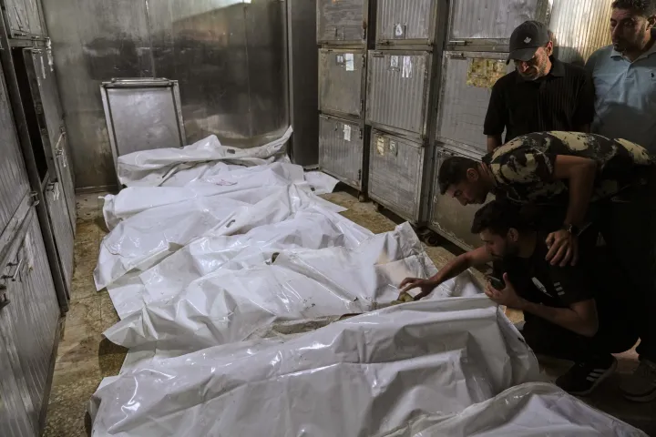 AP palestinians mourn over the bodies of people killed in an Israeli strike