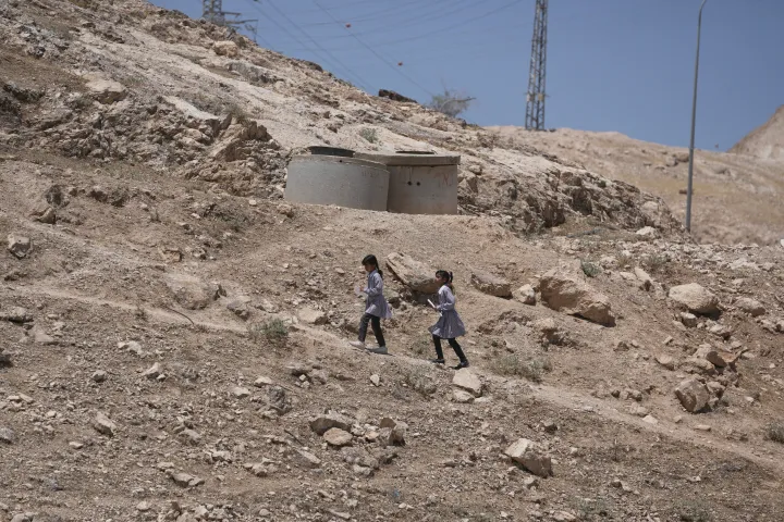 Palestinian students walk on their way home after receiving their year end reports from school