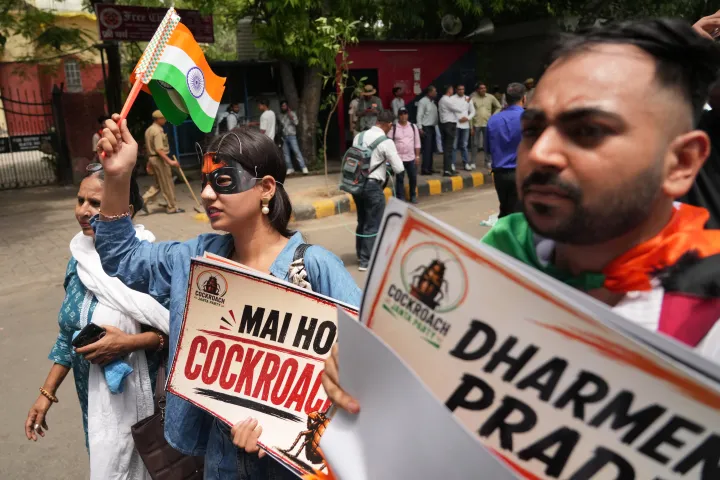 Supporters of the Cockroach Janta Party hold placards