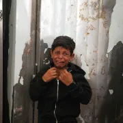 A Palestinian boy cries over the body of Hamouda al-Attar, who was killed by the Israeli army, during his funeral at al-Aqsa Hospital in Deir al-Balah, central Gaza Strip