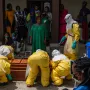 AP Family members of an Ebola victim mourn as the coffin