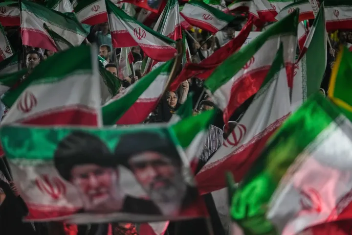 Pro-government Iranian demonstrators wave Iranian flags and a portrait of the Supreme Leader Ayatollah Mojtaba Khamenei