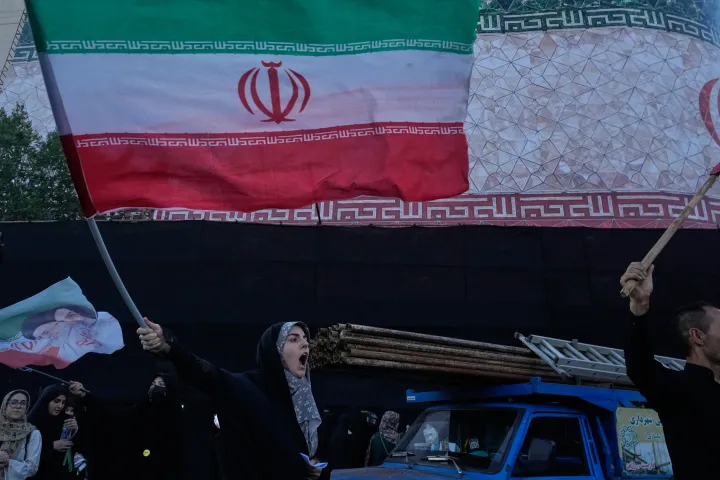 A woman waves an Iranian flags as she chants slogans against Iran and U.S. talks