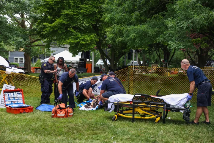 First responders help a woman who was injured the mass shooting that left 12 people injured 