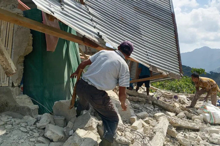 People examine the damage to a house following an earthquake in East Manggarai, East Nusa Tenggara province, Indonesia, Saturday,