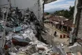A man rides his motorcycle past the ruins of homes destroyed five months earlier in an attack