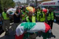 Mourners and paramedics carry the bodies of family members killed