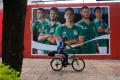 AP A cyclist passes by a photo of Mexico's national soccer team players in Mexico City