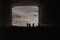 Palestinian children go through a vehicles tunnel on their way home