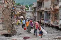 AP Residents carry their belongings salvaged from their damaged homes filled with mud and debris in Devighat, in Nepal's Nuwakot district